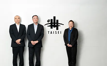 大成建設株式会社のオフィスで、3名の社員が並んで立っている様子（猪狩卓哉氏、宮地吾郎氏、鎌田美香氏）