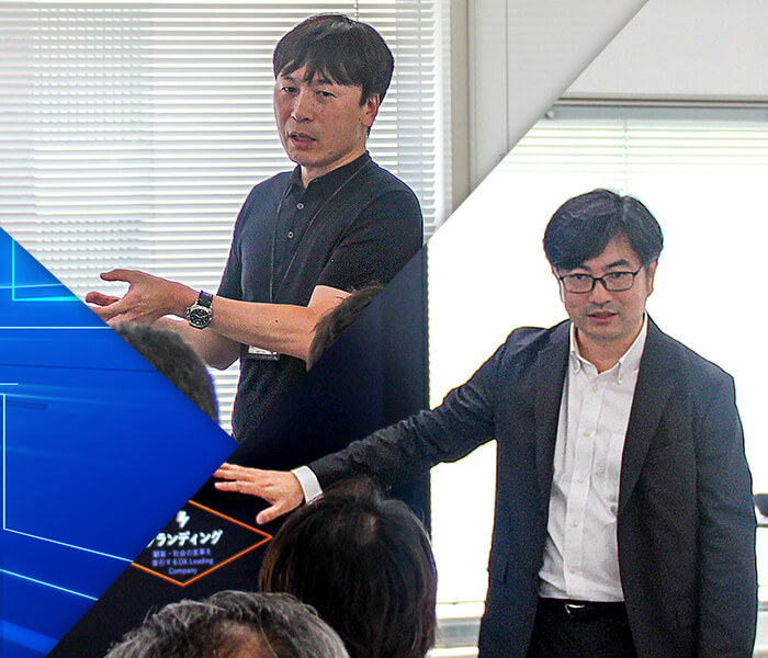講演中のNECコーポレートITシステム部門 経営システム統括部 ディレクター 馬場大輔と 基盤運用統括部 ディレクター 山本龍也の様子