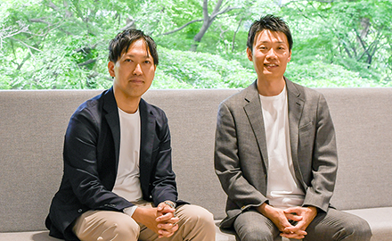 ソファに並んで座るNEC スマートインダストリー統括部 プロフェッショナル 高野智史とNEC スマートインダストリー統括部 プロフェッショナル 増本貴樹
